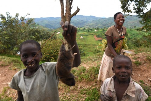 Dzieciaki prezentujące upolowanego szczura, który niebawem miał trafić na ich talerz.