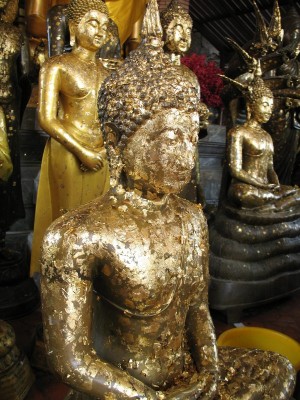 Ayutthaya - wierni przyklejają płatki złota na posągi Buddy, co ma im zapewnić pomyślność